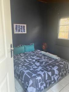 a bedroom with a bed with a blue and white comforter at Phola at my place in Durban