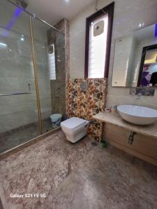 a bathroom with a toilet and a sink at BnBBuddy Athulyam 3 BHK Homestay, Shalimar Bagh in New Delhi