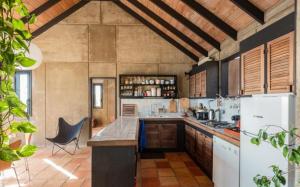a large kitchen with a counter and a refrigerator at Saint Barth Villa 8 in Pointe Milou