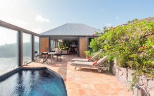 a house with a swimming pool and a patio at Saint Barth Villa 8 in Pointe Milou