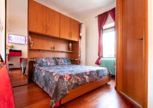 1 dormitorio con 1 cama y armarios de madera en Relax a 4 salti dai navigli, en Milán