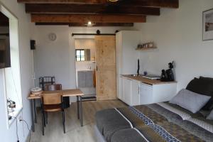a bedroom with a bed and a table and a kitchen at slapen aan de voet van de molen in Ovezande