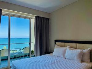 een slaapkamer met een bed en uitzicht op de oceaan bij The Sea Luxury Nha Trang Apartment in Nha Trang