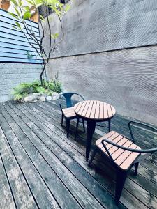 une table et deux chaises sur une terrasse en bois dans l'établissement Mo, à Houli