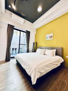 1 dormitorio con cama y pared amarilla en Mo en Houli