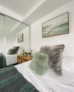 a bedroom with a bed with fuzzy pillows and a mirror at Penthouse 3 bedroom 6 guests 2 bathrooms in Melbourne