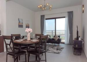 a dining room with a table and chairs in a living room at StoneTree - Furnished 1BR in Peaceful Community in Dubai