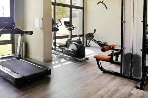 a gym with several exercise bikes and a treadmill at StoneTree - Furnished 1BR in Peaceful Community in Dubai