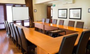 una sala de conferencias con una gran mesa de madera y sillas en Candlewoods Guesthouse, en Irene