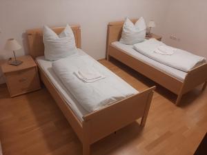- 2 lits avec des oreillers blancs dans une chambre dans l'établissement Pentling Ferienwohnung, à Pentling