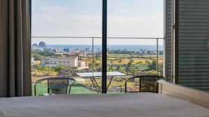 a room with a bed and a view of the ocean at Lucid M in Seogwipo