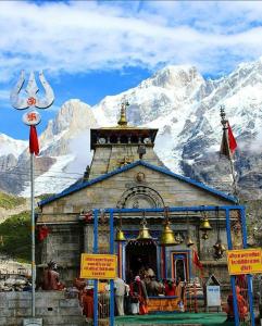 a small temple in front of a snow covered mountain at Bajwal Home-Stay & Guest-House in Sari