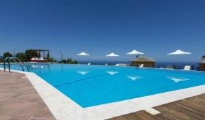 una gran piscina azul con sombrillas en Tilia Resort, en Mouresi