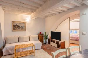 a living room with a bed and a tv at Elisa loft davanti alle Mura Lucca in Lucca