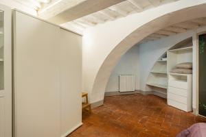 een kamer met witte muren en een boog bij Elisa loft davanti alle Mura Lucca in Lucca