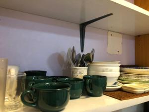 a bunch of green cups sitting on a shelf at Darling Vacation Rental Davao City in Davao City
