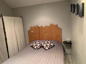 ein Schlafzimmer mit einem Bett mit zwei Kissen darauf in der Unterkunft Les Ouches in Fleurey-sur-Ouche