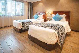 a hotel room with two beds and a window at Sarova Woodlands Hotel and Spa in Nakuru
