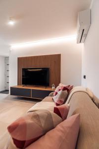 a living room with a couch and a flat screen tv at APARTMENTS Goldi Superior in Stahovica