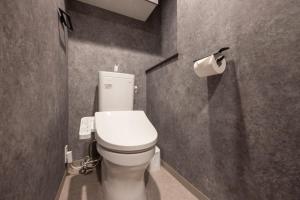 a bathroom with a toilet and a roll of toilet paper at ALTERNA Kuramae in Tokyo