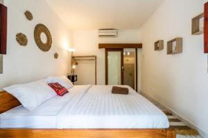 ein Schlafzimmer mit einem großen Bett mit weißer Bettwäsche in der Unterkunft Uda Suite Guest House 1 in Ubud