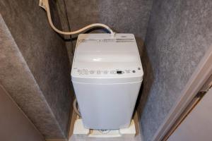 a washing machine in a corner of a room at ALTERNA Kuramae in Tokyo