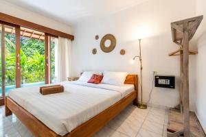 ein Schlafzimmer mit einem Bett und einem großen Fenster in der Unterkunft Uda Suite Guest House 1 in Ubud