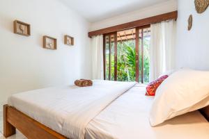 ein Schlafzimmer mit einem großen Bett und einem Fenster in der Unterkunft Uda Suite Guest House 1 in Ubud
