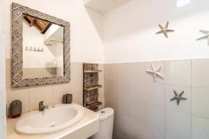 ein weißes Badezimmer mit einem Waschbecken und einem Spiegel in der Unterkunft Uda Suite Guest House 1 in Ubud