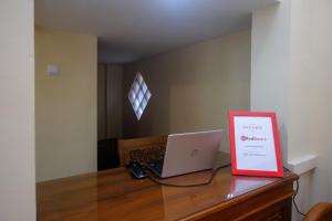 a desk with a laptop and a sign on it at RedDoorz Syariah @ Klodran Solo in Kadipiro +52 photos