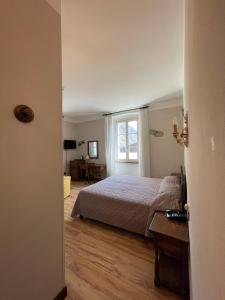 a bedroom with a bed and a window at Hotel La Torre in Castiglione dʼIntelvi