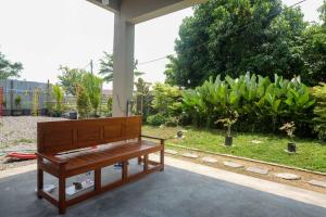 a wooden piano sitting on a patio next to a garden at RedDoorz Syariah @ Klodran Solo in Kadipiro