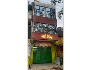 un bâtiment avec une porte verte et un panneau sur celui-ci dans l'établissement Hotel Khard Palace, Jhansi, à Jhansi