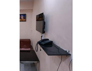a room with a desk with a phone and a tv at Hotel Khard Palace, Jhansi in Jhānsi