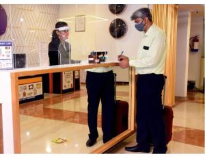 un homme portant un masque debout devant un miroir dans l'établissement Hotel Khard Palace, Jhansi, à Jhansi