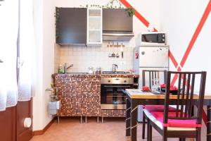 cocina con fogones y mesa con sillas en Relax a 4 salti dai navigli, en Milán