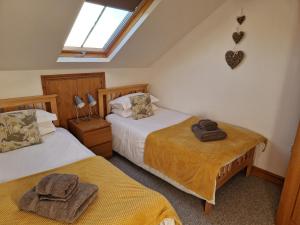a bedroom with two beds with towels on them at Rainors farm cottage in Gosforth
