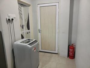 a door to a room with a trash can and a fire extinguisher at RINA HOMESTAY Kemaman in Cukai