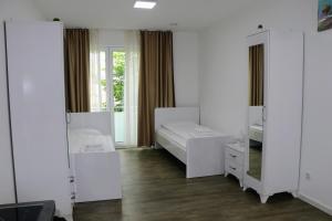 1 Schlafzimmer mit 2 Betten und einem Spiegel in der Unterkunft Apartments & Pension Burglesum in Bremen