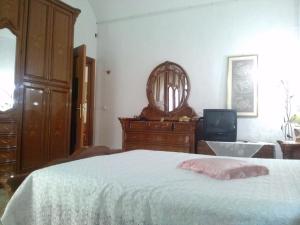a bedroom with a bed and a dresser and a mirror at Casa Leone in Noto