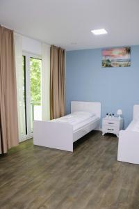ein Schlafzimmer mit einem weißen Bett und einer blauen Wand in der Unterkunft Apartments & Pension Burglesum in Bremen