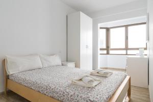 um quarto branco com uma cama com toalhas em Home2Book Charming Apartments La Naval La Isleta em Las Palmas de Gran Canaria