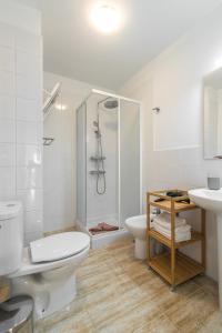 uma casa de banho branca com um WC e um chuveiro em Home2Book Charming Apartments La Naval La Isleta em Las Palmas de Gran Canaria