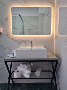 ein Badezimmer mit Waschbecken, Spiegel und Handtüchern in der Unterkunft Hotel Meduza Olimp in Olimp + 96 Fotos