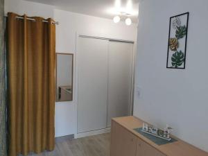 ベルニエール・シュル・メールにあるAppartement accès direct à la plageのシャワーカーテンと木製のテーブルのある部屋