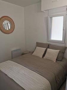 ベルニエール・シュル・メールにあるAppartement accès direct à la plageの窓付きの白い部屋のベッド1台 +18枚の写真