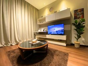 a living room with a coffee table and a flat screen tv at D'CASA Riverson at Kota Kinabalu in Kota Kinabalu
