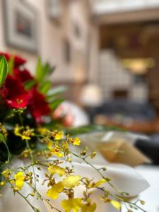 un plato blanco con flores en una mesa en Betel Nut Lodge, en George Town