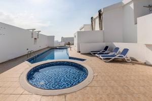 una piscina sul tetto di un edificio con sedie di Amazing 1BR Apt at silicon oasis Dubai for family a Dubai