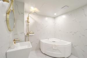 bagno bianco con servizi igienici e lavandino di Hotel Palace Gyeongju a Gyeongju